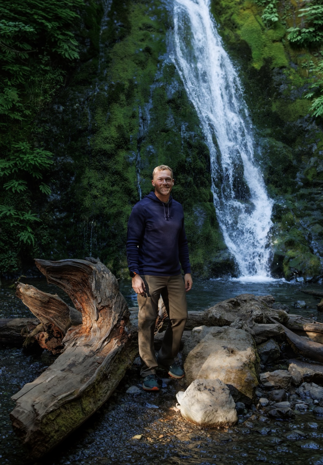 Matt Blaser standing beside a waterfall